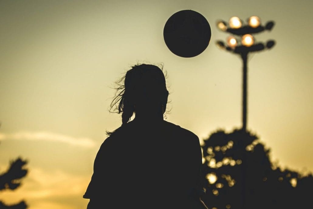 OAKVILLE, ON - AUG. 15, 2016: A silhouetted player brings down the ball under a golden sunset.