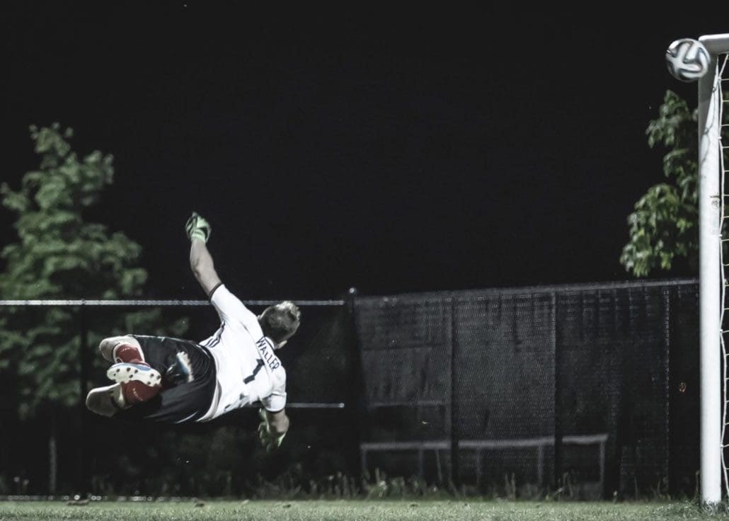 OAKVILLE, ON - JUN. 14, 2016: A goalkeeper dives helplessly for a shot destined for the top-left corner.