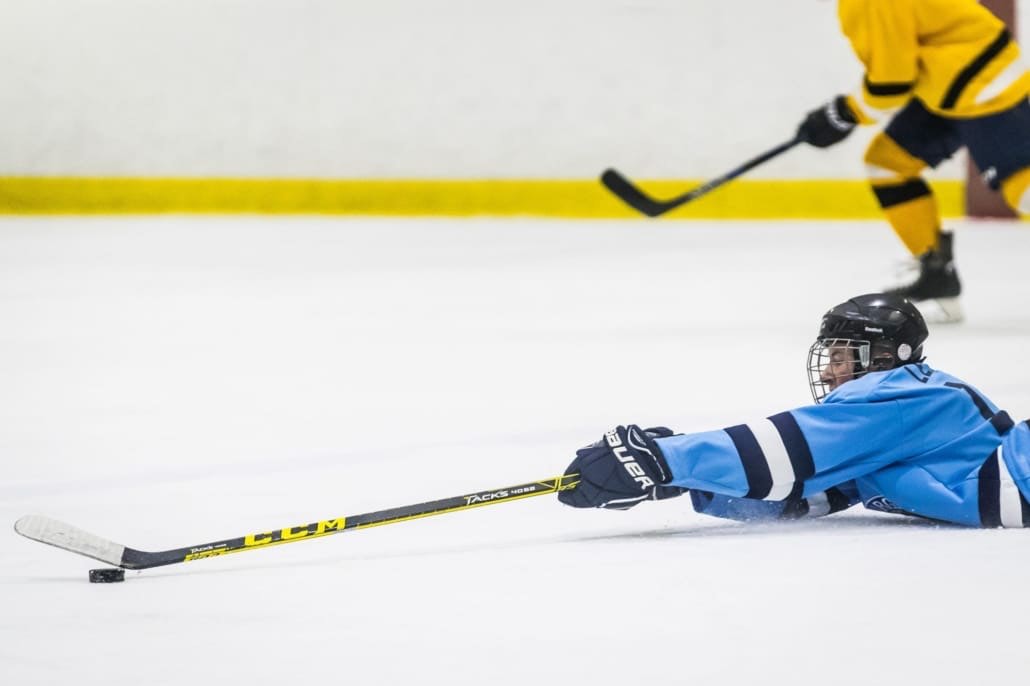 BURLINGTON, ON - Jan. 27, 2017: A Penguins player stretches to pass the puck while on the ice.